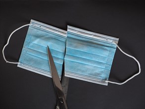Proper disposal of used medical mask cut to prevent reuse