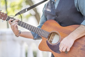 Professional guitarist plays guitar outdoors. Musician plays a classical guitar in the park
