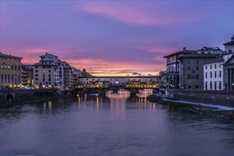 View of the iconic Ponte Vecchio over the Arno River at dusk in Florence