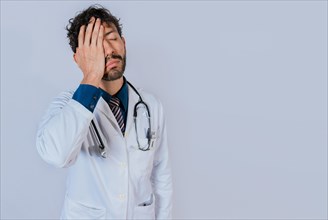 Exhausted doctor with hand on his forehead. Overworked doctor with hand on forehead isolated