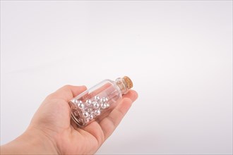 Little perfume glass bottle in hand on a white background