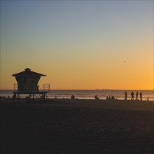 A typical californian lifeguard and people watching sunset