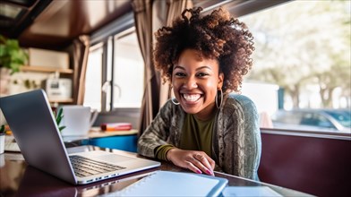 Happy african american young adult female enjoying working remotely inside her RV camper trailer