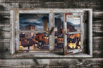 View of Bologna in the evening light through a wooden window