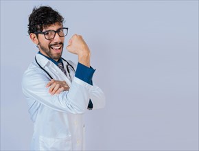 Doctor showing muscle. Young doctor showing strength with his arm