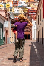 Mother with her son in her arms in the city of San Sebastian de la Gomera next to the Iglesia De La Asuncion