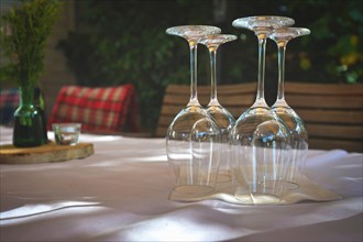 Elegant table at restaurant with arranged empty wine glasses turned upside down on blurry background