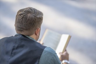 Business man reading a book in a park