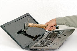 Arm of a man breaking a laptop with a hammer isolated on white background and copy space