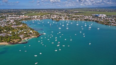 Aerial view from bird's eye view of large sea bay Grand Baie with pleasure boats motor yachts sailboats anchored in sheltered bay