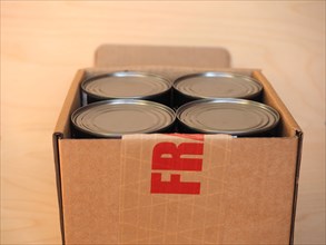 Fragile cardboard box with tin cans