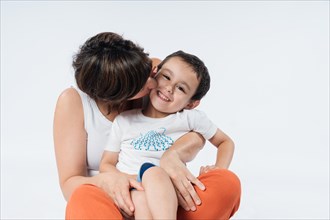 Mom hugs and kisses her little son. Family concept