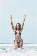 Sensual portrait of latina woman having fun on the shore of the beach