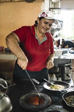 Woman cooks on a wood stove. Typical Costa Rican Restaurant. Local people and traditional food