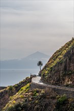 Road in the village of Agulo in the north of La Gomera with a palm tree and Tenerife in the background