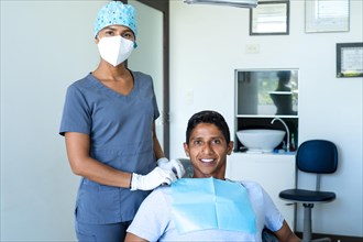 Portrait of happy male patient and pretty young female dentist looking at camera. Concept of whitening