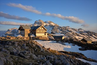 Hiker enjoying the sunset at Ingolstaedter Haus in the Steinernes Meer