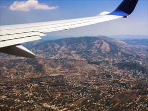 View of airplane wing against mountains