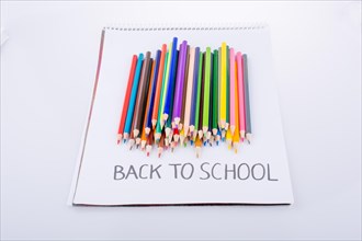 Color pencils and back to school title on a notebook