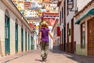 Woman on vacation walking through the city of San Sebastian de la Gomera next to the Iglesia De La Asuncion