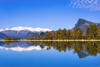 Scenic view at Lake Laitaure in rapa valley at Sarek national park with autumn colors and snow capped mountains
