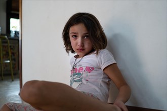 Crying girl sitting on the floor at home isolation during quarantine COVID 19 Outbreak
