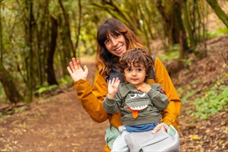 Mother and son having fun trekking on the trail in the mossy tree forest of Garajonay National Park