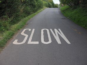 Slow sign painted on tarmac on a british road