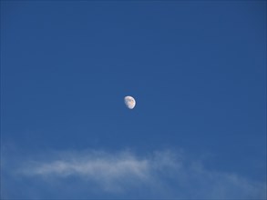 Waxing gibbous moon over blue sky