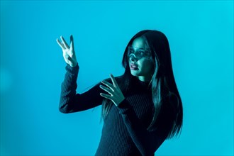 Technology concept. Woman in futuristic glasses with led light on a blue background
