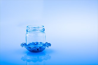 Little empty jar on a plate on a colorful background