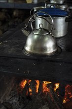 Close up of stainless steel kettle on a burning wood stove. Popular culture. Traditional food