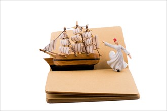 Sufi Dervish and a ship on a notebook on white background