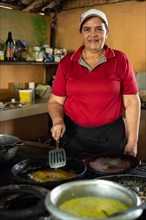 Latin mature woman looking at the camera while cooking a typical Costa Rican meal