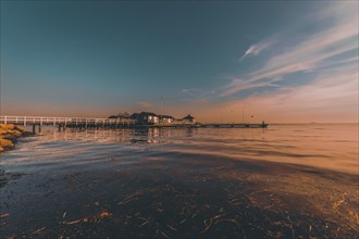 Seascape with pier at sunset