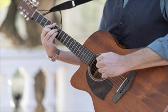 Professional guitarist plays guitar outdoors. Musician plays a classical guitar in the park