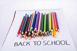 Color pencils and back to school title on a notebook