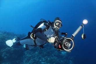 Cameraman with professional underwater video camera type RED Dragon X 6K Digital Cinema Camera in Nauticam underwater housing