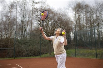Subject: Woman aged 83 standing on the tennis court.