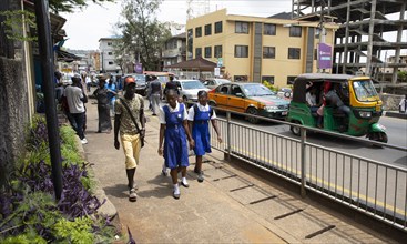 Street scene with school children and TukTuks in Freetown