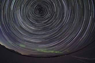 Star trails with faint northern lights over Tornetraesk lake
