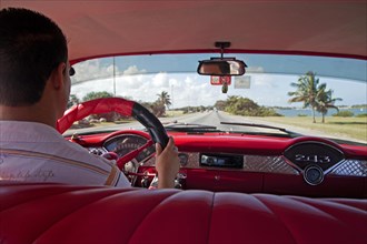 Cuban taxi driver and interior of old 1950s vintage American car