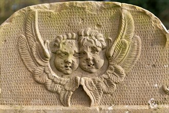 Faces of two cherubs or angels carved on gravestone