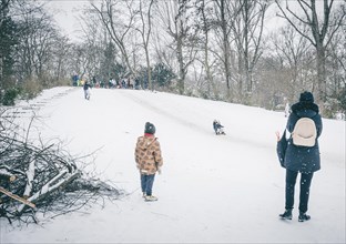 People tobogganing on a small mountain in Kreuzberg in Berlin in the snow. 09.02.2021.