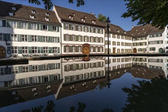Cathedral houses reflected in the fountain on Muensterplatz in Basel