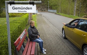 Car driver stops at a carpooling bench in Tiefenbach. In places where public transport does not offer sufficient options