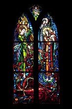Stained-glass window picturing Saint Michael fighting dragon