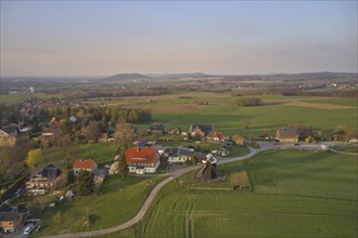 Aerial view of the district of Kottmarsdorf in the Saxon municipality of Kottmar with the Kottmarsdorf mill against the mountainous landscape of Upper Lusatia. Kottmar