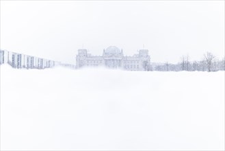 The Reichstag building is silhouetted against snowfall in the government district in Berlin