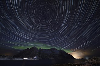 Star trails with some northern lights and rain clouds near Henningsvaer